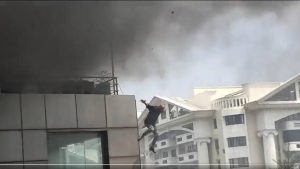 El aterrado hombre mira el fuego hacia su derecha y luego hacia el suelo antes de saltar.