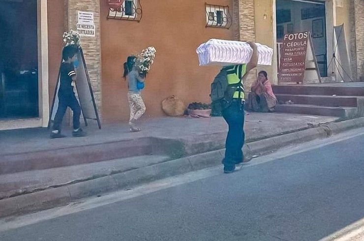 Padre carga el ataúd de su bebé y sus hijos llevan las flores