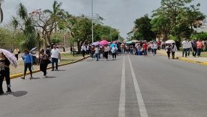 Manifestantes con pancartas y carros de sonido exigen la abrogación de la ley del ISSTE 2007 durante el bloqueo en el Aeropuerto de Mérida.