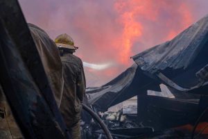 Bomberos realizan las labores de enfriamiento para evitar rebrotes después de sofocar el incendio en el Periférico de Mérida.