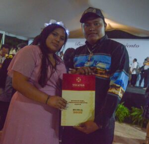 La emoción se desborda mientras Micaela y Santos Aurelio reciben su acta matrimonial en las Bodas del Renacimiento Maya 2025 en Xmatkuil, acompañados de su familia.