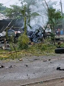 Escena del lugar donde ocurrió la explosión de coche bomba en Michoacán, mostrando los daños en comercios y vehículos tras el impacto.