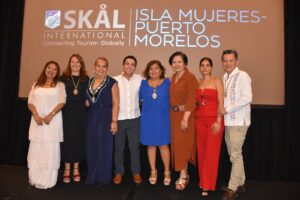 Integrantes de la nueva mesa directiva de Skål Internacional 723 Isla Mujeres–Puerto Morelos acompañan a Irma Alviso Rentería tras su toma de protesta, en un evento que reunió a líderes del sector turístico.