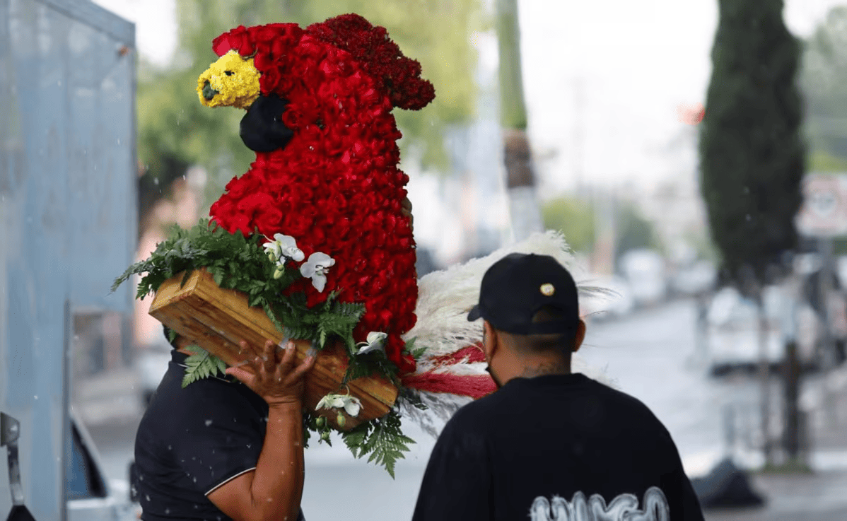 Funeral con arreglos florales y símbolos alusivos