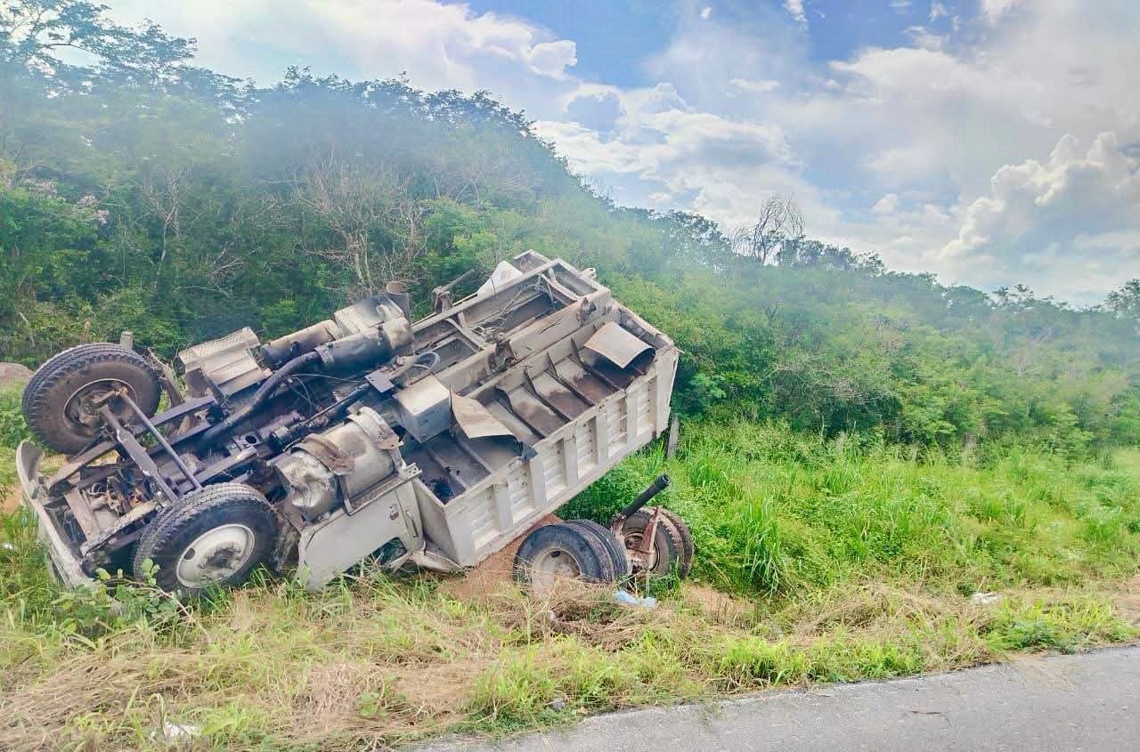 Camión de volteo sale de carretera y termina volcado entre maleza